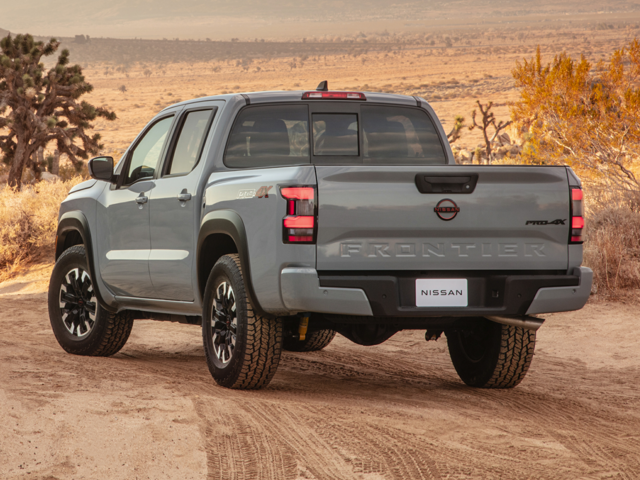 Rear profile view of a grey 2024 Nissan Frontier parked on a dirt road. | Nissan dealer in Norfolk, VA | Banister Nissan of Norfolk