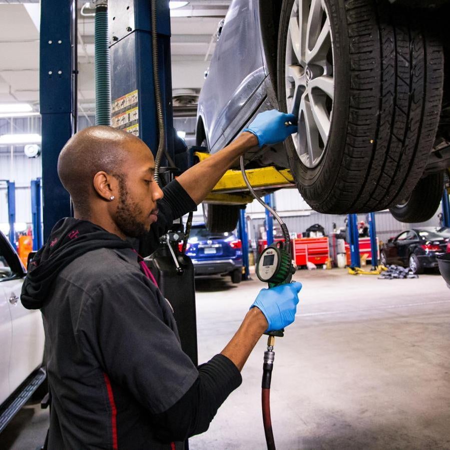 a dealer technician working on a nissan